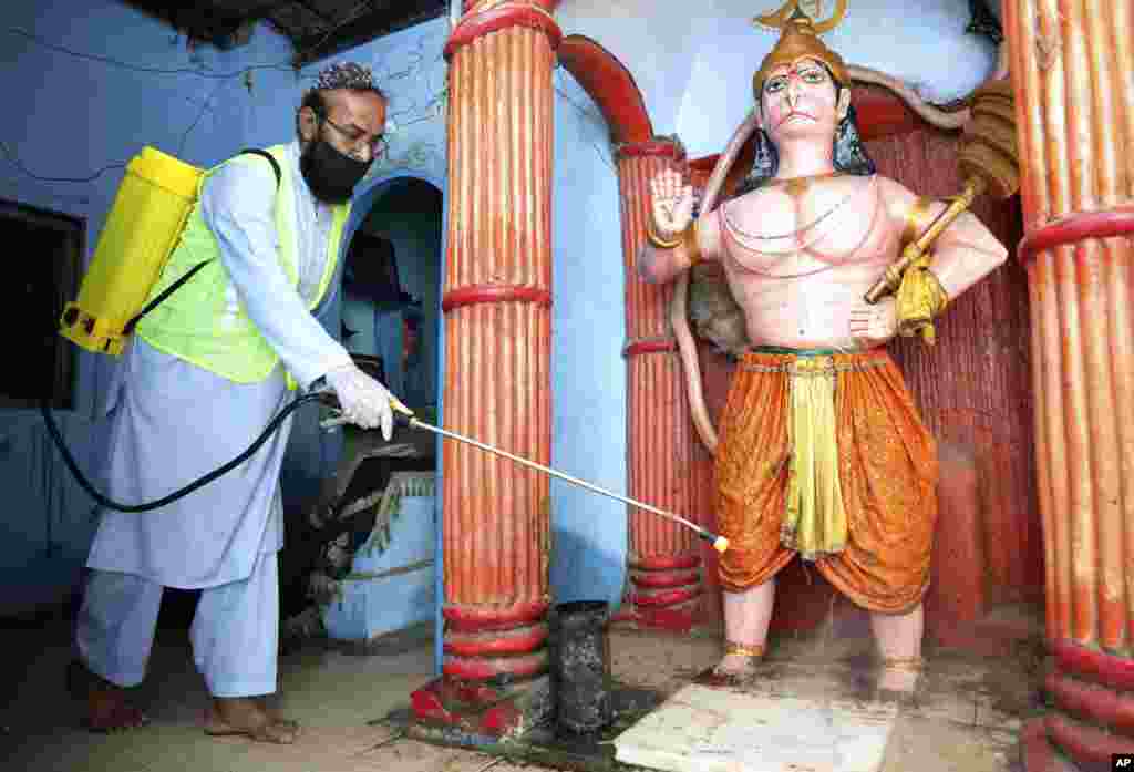 Un voluntario desinfecta un templo hindú en un esfuerzo por contener el brote del coronavirus, en Karachi, Pakistán.