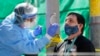Tina Nguyen, a la izquierda, enfermera de la clínica International Community Health Services en el Distrito Internacional de Seattle, toma una muestra de hisopo de la nariz de David Carroll, un empleado de ICHS.