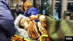 Petugas paramedis membawa salah satu korban yang terluka meninggalkan bandara Domodedovo, Senin (1/24).