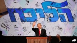El primer ministro de Israel, Benjamin Netanyahu, saluda a sus partidarios desde la sede de su partido, el Likud, luego de los primeros resultados de encuestas a boca de urna en las elecciones parlamentarias. Jerusalén, marzo 24 de 2021.