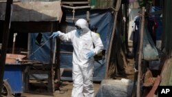 A member of the non-profit Cambodian Children's Fund sprays disinfectant to help curb the spread of the new coronavirus in the slum neighborhood of Stung Meanchey in southern Phnom Penh, Cambodia, March 24, 2020.