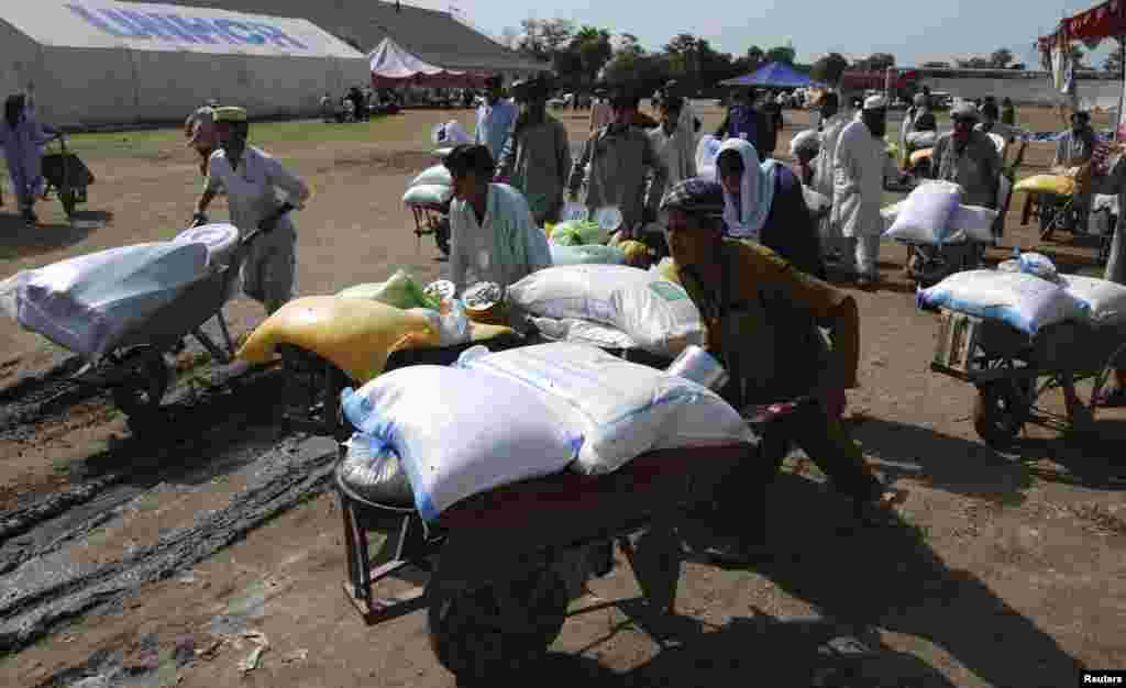 Des gens qui ont fui l'offensive militaire contre les militants pakistanais dans le Waziristan du Nord, repartent avec des brouettes de documents de secours après avoir reçu une tente de stockage du Programme alimentaire mondial (PAM) à un point de distribution pour déplacés.