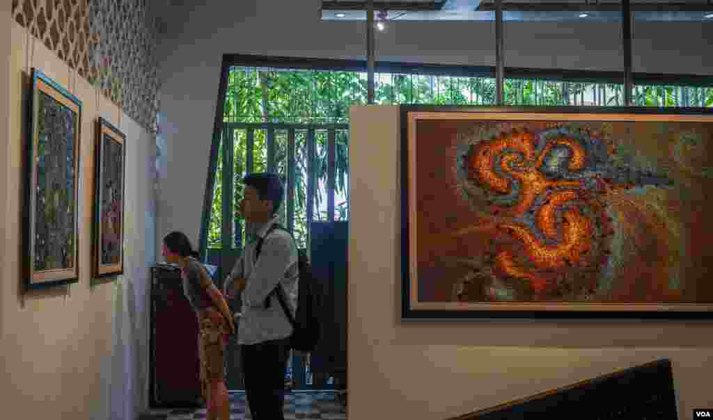 សាធារណជនសញ្ជឹងមើលផ្ទាំងគំនូររបស់ វិចិត្រករ សាង ណាន់ ដែលបង្ហាញនូវភាពឈឺចាប់ និងក្តីសង្ឃឹមរបស់ប្រជាជនខ្មែរដែលបានរស់ក្នុងសម័យខ្មែរក្រហម និងតស៊ូក្នុងជីវិតបច្ចុប្បន្ន។ គំនូរទាំង១១ ផ្ទាំងរបស់លោកត្រូវបានតាំងបង្ហាញនៅកម្មវិធីមហោស្រពភាពយន្តអន្តរជាតិកម្ពុជាលើកទី៩, នៅរាជធានីភ្នំពេញ, នៅថ្ងៃទី១២ ខែមីនា ឆ្នាំ២០១៩។ (ខាន់ សុគុំមនោ/VOA)