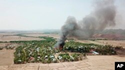In this photo released by the Myanmar Army, a fire burns May 16, 2020, in the predominantly ethnic Rakhine village of Let Kar in Rakhine State's Mrauk-U township, western Myanmar.
