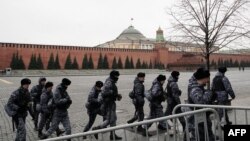 Oficiales de la Guardia Nacional Rusa caminan junto al muro del Kremlin en Moscú el 23 de marzo de 2024.