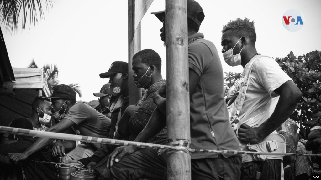 Los grupos de migrantes que viajan juntos se turnan en las largas filas en el Puerto de Necoclí, con la esperanza de hacerse con uno de los más de 700 boletos que se venden al día.