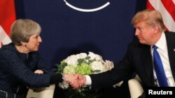 FILE - U.S. President Donald Trump shakes hands with Britain's Prime Minister Theresa May during the World Economic Forum annual meeting in Davos, Switzerland, Jan. 25, 2018.