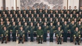 In this photo released by Xinhua News Agency, Chinese President Xi Jinping poses for photos with military personnel of the Chinese People's Liberation Army garrison stationed in the Macao Special Administrative Region in southern China, Dec. 20, 2024. (Li Gang/Xinhua via AP)