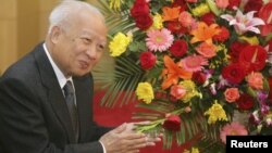 Cambodian King Norodom Sihanouk stands beside flowers given by the Chinese government during a meeting with Chinese State Councilor Dai Bingguo (not seen) in Beijing, October 30, 2006.