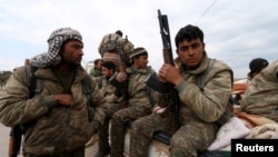 FILE - Kurdish People's Protection Units (YPG) fighters are seen riding on the back of a pick-up truck in Qamishli, Syria, March 11, 2016. Turkey accuses the YPG of seeking to create an independent Kurdish state.