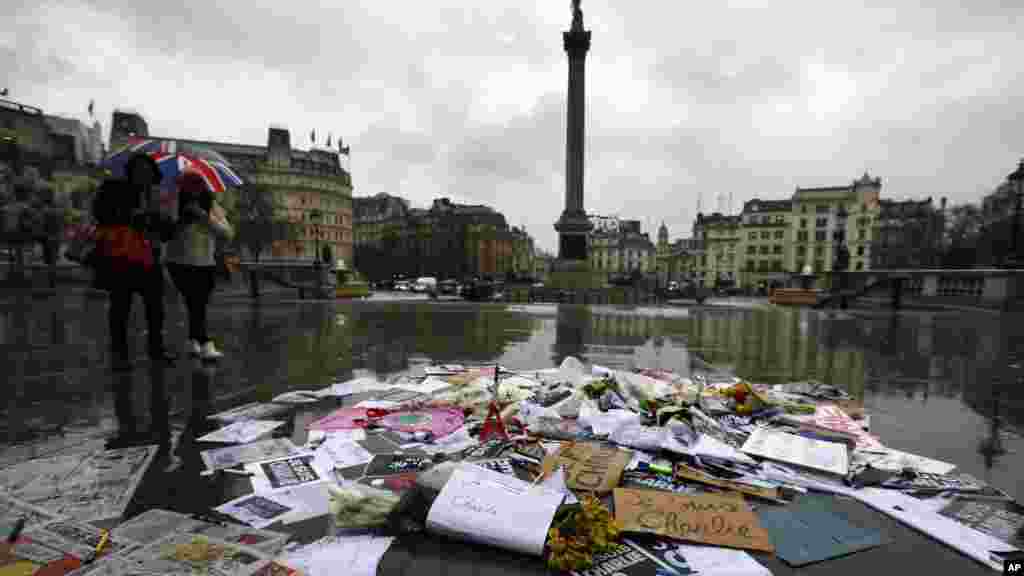 Des fleurs et des stylos et des pancartes sont déposés en signe de solidarité avec les personnes tuées dans une attaque dans les bureaux parisiens de l'hebdomadaire Charlie Hebdo, à Trafalgar Square, à Londres, le 8 janvier 2015.
