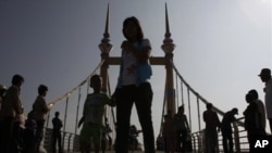 Cambodians walk on a bridge (now removed) on which hundreds of people stampeded during a water festival on Nov. 22, 2010.