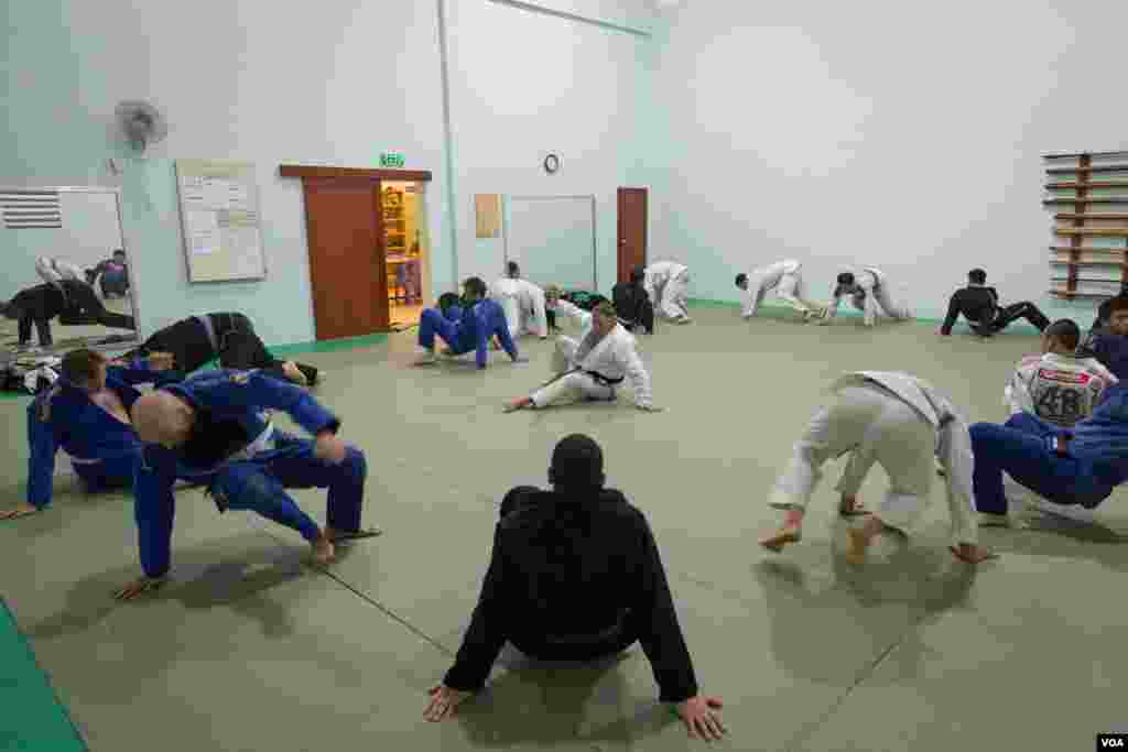Chris Haueter (in white), one of the well-known BJJ trainers, shows a Jiu Jitsu's technique to a group of expats during a training at the Olympic Stadium, in Phnom Penh, on February 22, 2016. (Neou Vannarin/VOA Khmer)