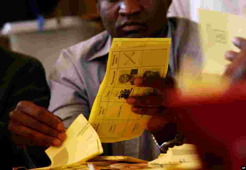 Electoral officials count ballots in Domboshawa, near the capital Harare Saturday, April 19, 2008. Officials began recounting votes for a couple dozen legislative seats, an exercise that could overturn the opposition's landmark victory. The ruling party is challenged the count in 23 constituencies, most won by the opposition.