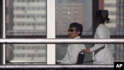 Chinese activist activist Chen Guangcheng (L) is seen in a wheelchair pushed by a nurse at Chaoyang hospital in Beijing, May 2, 2012.