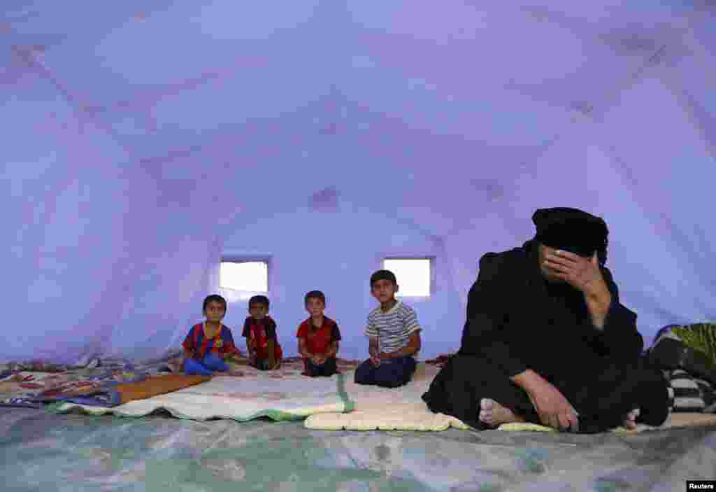 "Iroq va Shom islomiy davlati" jangarilari Mosulni o'z nazoratiga olgach, shahardan qochib chiqqan oila Kurdiston viloyatidagi Arbil shahriga tikilgan o'tov ichida, 12-iyun, 2014-yil.