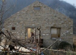 A man is seen inside a destroyed house in the village of Knaravan located in a territory which is soon to be turned over to Azerbaijan, Nov. 15, 2020.