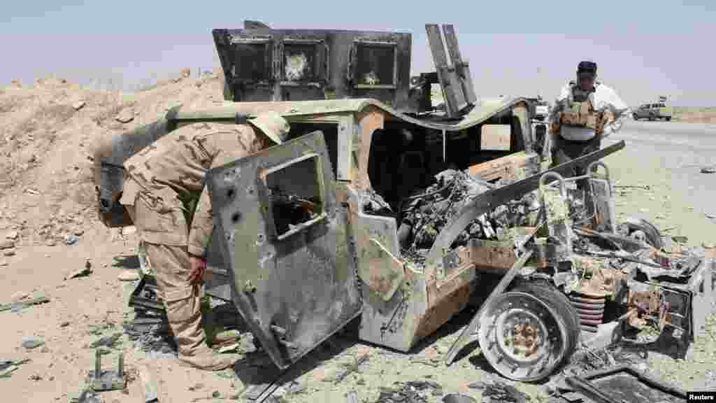 The wreckage of a Humvee belonging to Islamic State militants lies along a road after it was targeted by Iraqi security forces and Iraqi Shi'ite volunteers, in the town of Sulaiman Pek in Salahuddin province, Aug. 31, 2014.