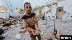 Palestinci pregledaju mjesto izraelskog napada na skladište pomoći u izbjegličkom kampu Al-Nuseirat