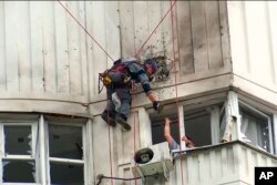 俄羅斯調查人員在檢查一架烏克蘭無人機對莫斯科一座公寓樓造成的損害。(2023年5月30日)