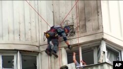 視頻截圖顯示調查人員正在查看莫斯科一棟被烏克蘭無人機襲擊的建築。(2023年5月30日)