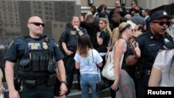 FILE - Family members of detainees line up to enter a federal court just before a hearing to consider a class-action lawsuit filed on behalf of Iraqi nationals facing deportation, in Detroit, Mich., June 21, 2017.