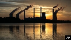 FILE - The coal-fired Plant Scherer, one of the nation's top carbon dioxide emitters, stands in the distance in Juliette, Ga., June 3, 2017. The Trump administration intends to roll back the centerpiece of former President Barack Obama’s efforts to slow g