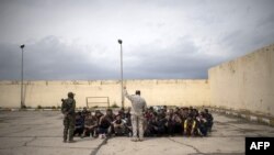 ARCHIVO_Desplazados iraquíes reciben instrucción antes de ser procesados y enviados a un campo de refugiados en el oeste de Mosul, Irak.
