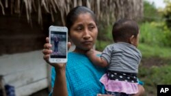 Claudia Maquin, de 27 años, muestra una foto de su hija Jakelin Amei Rosmery Caal Maquin en Raxruha, Guatemala, el sábado 15 de diciembre de 2018.