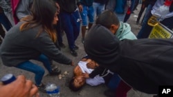 ARCHIVO - Personas ayudan a un hombre herido durante protestas antigubernamentales en Arequipa, Perú, en enero de 2023. 
