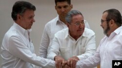 Cuba's President Raul Castro (Center) encourages Colombian President Juan Manuel Santos (Left) and Commander the Revolutionary Armed Forces of Colombia or FARC, Timoleon Jimenez, to shake hands, in Havana, Cuba, Sept. 23, 2015.