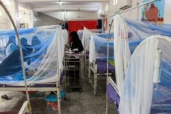 FILE - Women wait with children in a ward at a malnourishment treatment center in Yemen's northern Hajjah province, Nov. 22, 2020.