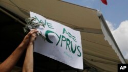 Wani dan kasar Cyprus dauke da kwalin mai rubutun nuna kishin kasa