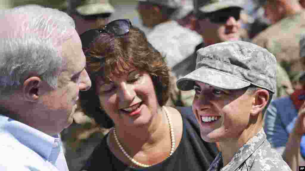 La première lieutenant Shaye Haver de l’armée américaine, à droite, sourit après avoir reçu le précieux petit bout d'étoffe noir et or, d'un homme non identifié au cours d’une cérémonie de remise des diplômes vendredi 21 août 2015, à Fort Benning, en Géorgie.