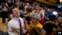 Democratic presidential candidate former South Bend, Ind., Mayor Pete Buttigieg, left, reacts as he greets members of the audience during a campaign stop at Iowa State University, Monday, Jan. 13, 2020, in Aimes, Iowa. (AP Photo/Andrew Harnik)