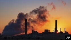 FILE - In this July 27, 2018, file photo, the Dave Johnson coal-fired power plant is silhouetted against the morning sun in Glenrock, Wyo. 