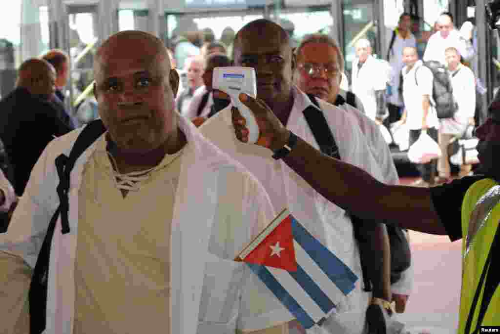 Cuban health workers have their temperatures taken upon arrival at Roberts International Airport outside Monrovia, Liberia, Oct. 22, 2014.