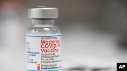 ARCHIVO - Un vial de la vacuna de Moderna para el COVID-19 es visto en el mostrador de una farmacia en Portland, Oregon, en diciembre de 2021.