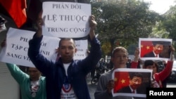 Protesters hold marked images of Chinese President Xi Jinping and anti-China signs during a protest ahead of his visit to Vietnam, on the street in Hanoi November 3, 2015. REUTERS/Kham - RTX1UHQG