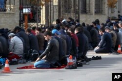 FILE - Men attend a Friday prayer at the mosque on Kotrova street in Dagestan's regional capital Makhachkala, Russia, Nov. 13, 2015.