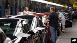 FILE - In this June 15, 2010, file photo, workers at General Motors' plant in Lordstown, Ohio put the final touches on new vehicles.