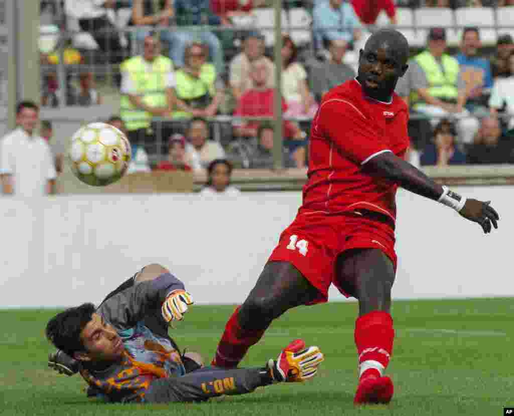 L'ancien footballeur libérien George Weah , à droite, marque un but au cours du match de son jubilé joué à Marseille, au Sud de la France, samedi 11 juin 2005. Weah a annoncé sa candidat aux prochaines élections pour le Sénat après au Liberia.
