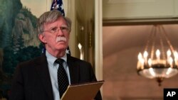 Le conseiller à la sécurité nationale, John Bolton, écoute le président Donald Trump dans la salle de réception diplomatique de la Maison-Blanche, à Washington, le 13 avril 2018.