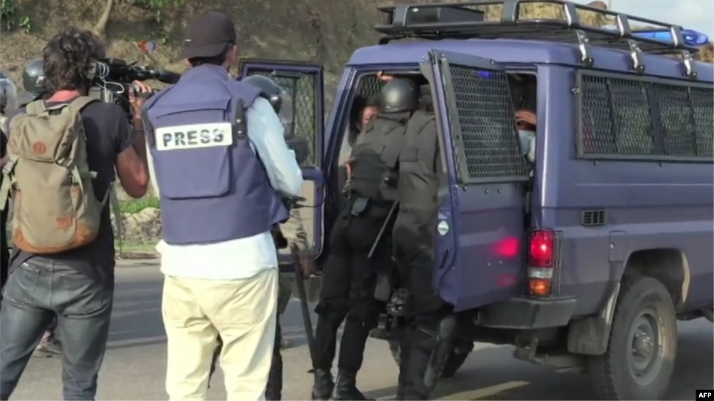 Les forces de l’ordre embarquent dans un véhicule des manifestants arrêtés sous le regard des journalistes, à Libreville, Gabon, 31 août 2016.