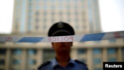 Seorang petugas kepolisian berjaga di depan pengadilan Jinan di provinsi Shandong, 24 Agustus 2013 (Foto: dok). 