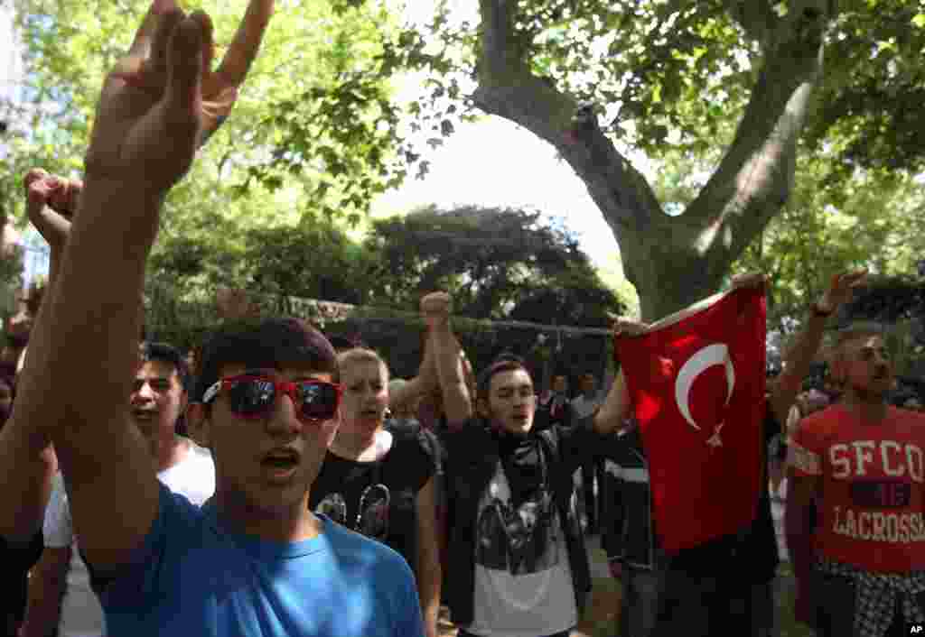 Siswa-siswa sekolah menengah atas menyanyikan lagu kebangsaan Turki dalam protes di Taman Gezi dekat Alun-Alun Taksim, Istanbul (3/6). (AP/Thanassis Stavrakis) 