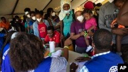 Haitians who were deported from US border with Mexico are attended by members of the IOM UN Migration organization before they get tested for COVID-19 at Toussaint Louverture International Airport in Port-au-Prince, Haiti, Sept. 20, 2021.