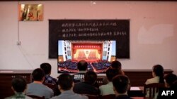 廣西柳州一個村莊的村民正在觀看在北京人大會堂舉行的全國脫貧攻堅總結表彰大會的電視直播。 （2021年2月25日）