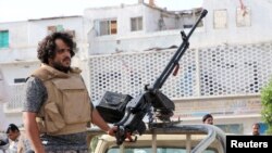 A fighter of the southern Yemeni separatists mans a machine gun mounted on a military vehicle securing an anti-government protest in Aden, Yemen, Jan. 28, 2018.