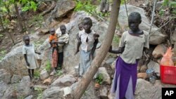 Sudanese children displaced from their homes in the rebel stronghold of Kauda take shelter in the hills surrounding the town in the Nuba mountains as they flee with their families from government bombardment, June 30, 2011